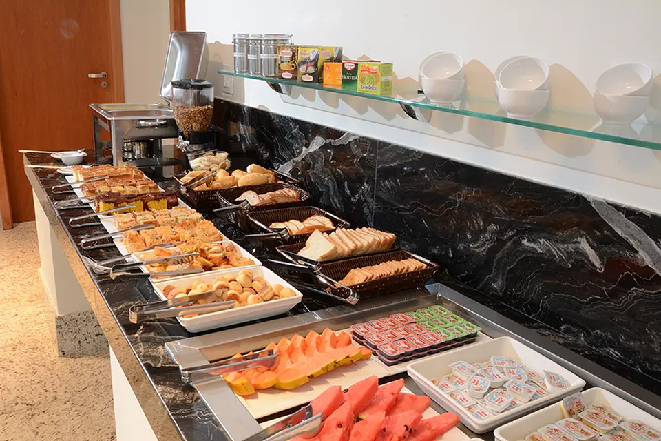 Mesa do café da manhã com pães, bolos e frutas
